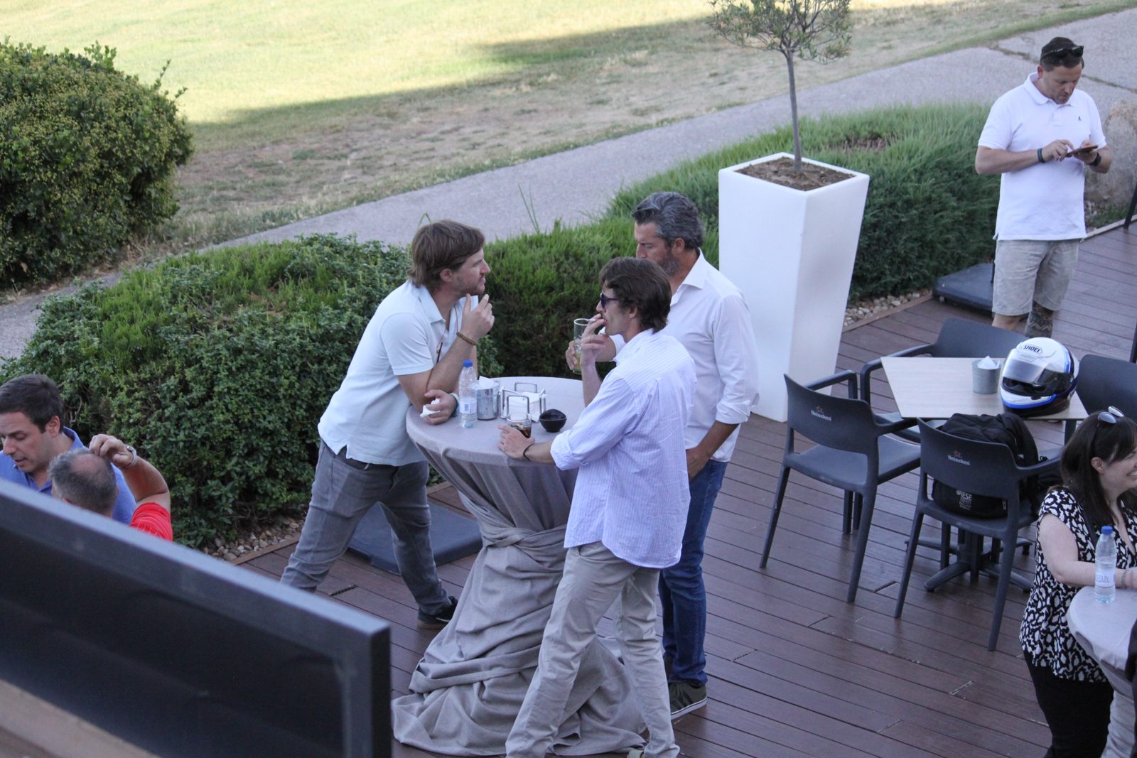 Asistentes charlando en la terraza del Club de Golf Olivar de la Hinojosa