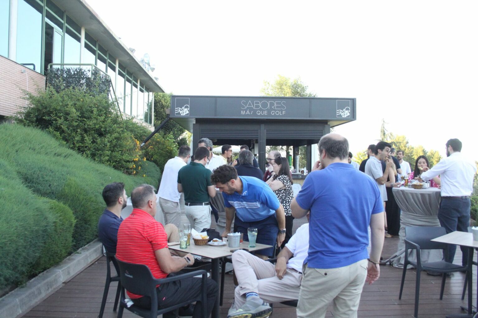 Asistentes conversando en la terraza del club durante el networking